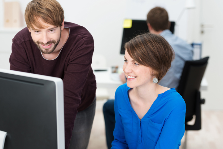 Mujer-y-hombre-trabajando-en-computadora-sonrientes