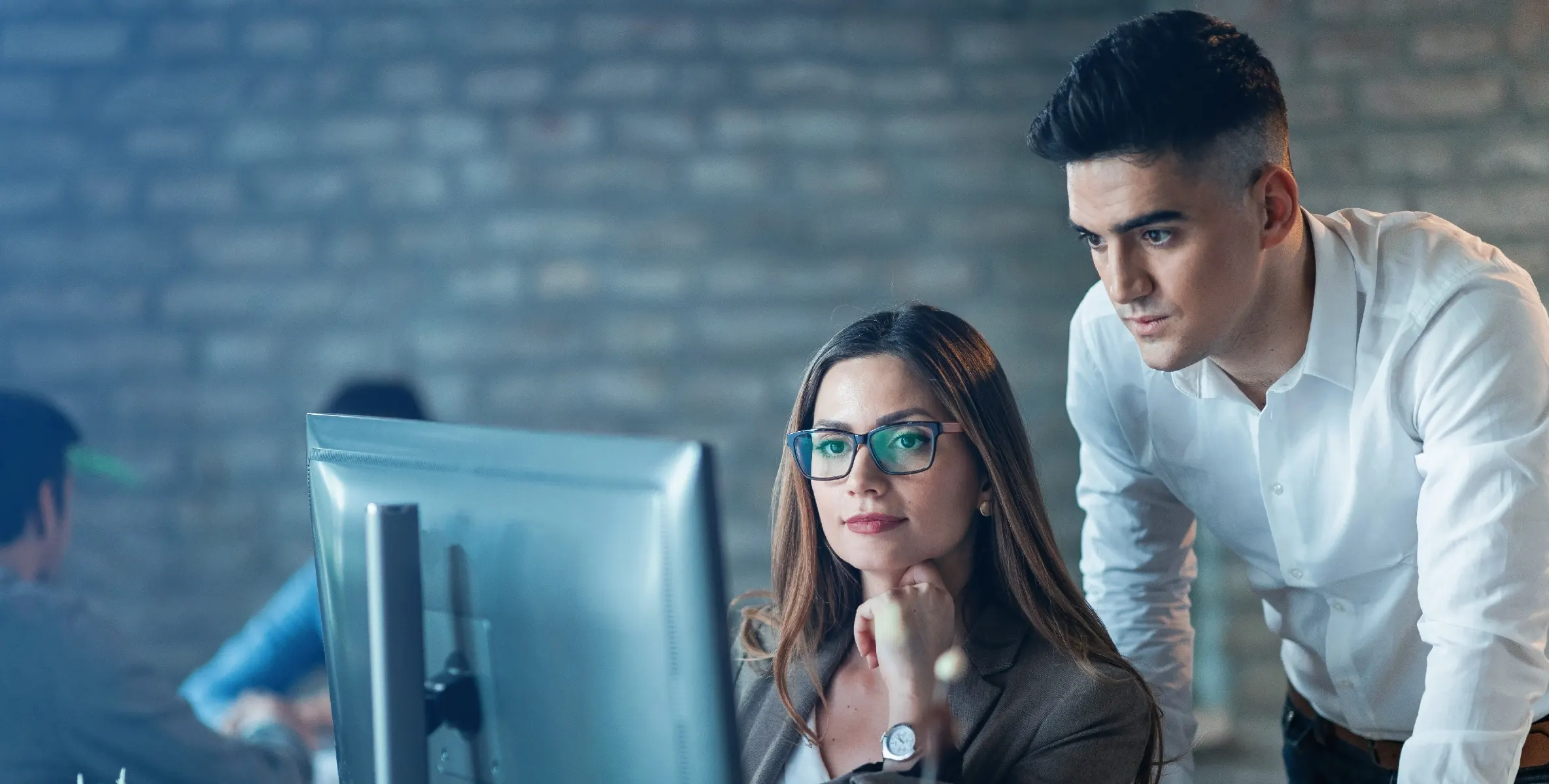 Hombre-y-mujer-joven-trabajando-frente-a-computadora